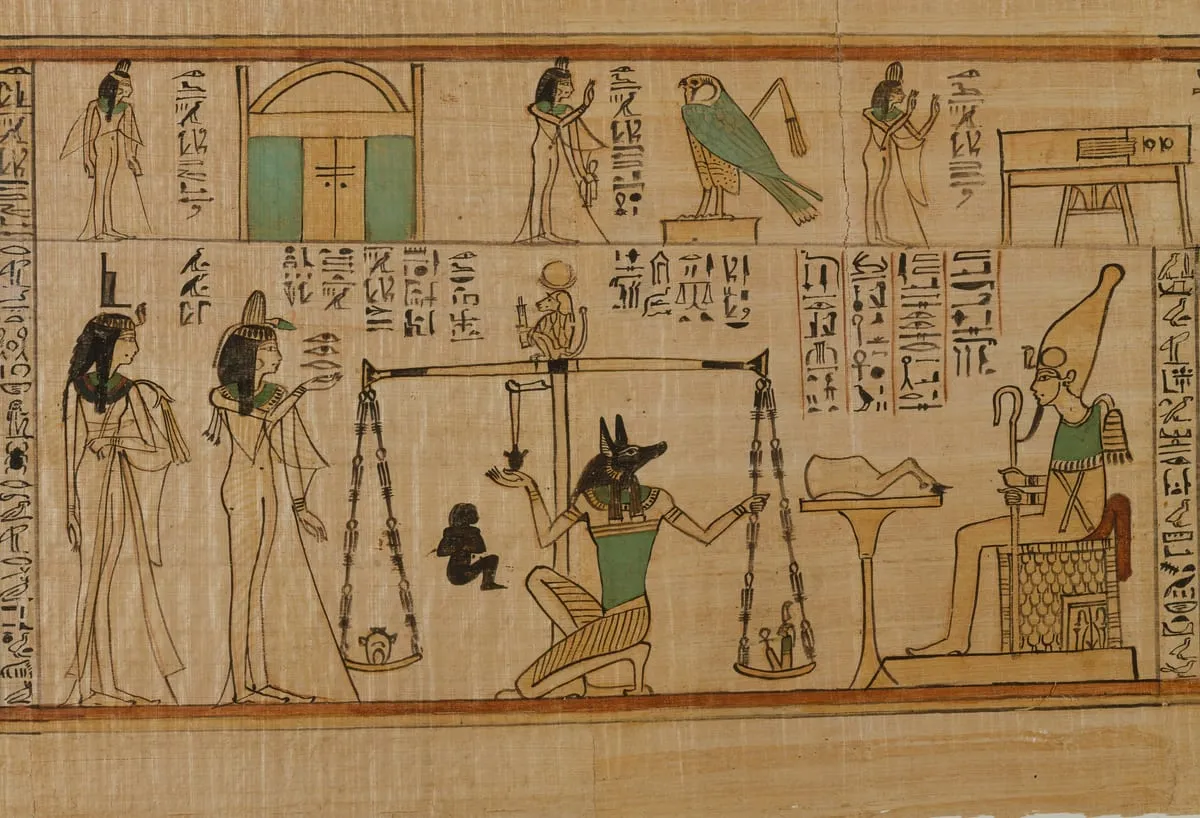 Ausschnitt aus einem bemalten Papyrus im Querformat, in zwei Streifen gegliedert. Im unteren, größeren Streifen steht in der Mitte eine hohe Standwaage: An ihrem Balken hängen zwei Schalen, in der linken ein kleiner rundlicher Gegenstand, in der rechten eine winzige hockende Figur. Auf dem Balken sitzt ein kleiner Affe mit runder Scheibe über dem Kopf. Neben der Waage kniet eine Gestalt mit schwarzem Schakalkopf und fasst nach den Schnüren. Links davon stehen zwei Frauen in langen weißen Gewändern, die vorderste mit erhobener Hand. Rechts sitzt auf einem Thron eine Gestalt mit hoher kegelförmiger Krone, Krummstab und Wedel in den Händen; davor steht ein Tisch mit Gaben. Der obere Streifen zeigt eine Doppeltür, stehende Frauen mit erhobenen Armen und einen grünen Falken auf einem Sockel. Zwischen allen Figuren stehen Kolumnen mit Hieroglyphen; der Papyrus ist hellbraun, die Farben sind auf Grün, Schwarz und Ocker beschränkt.